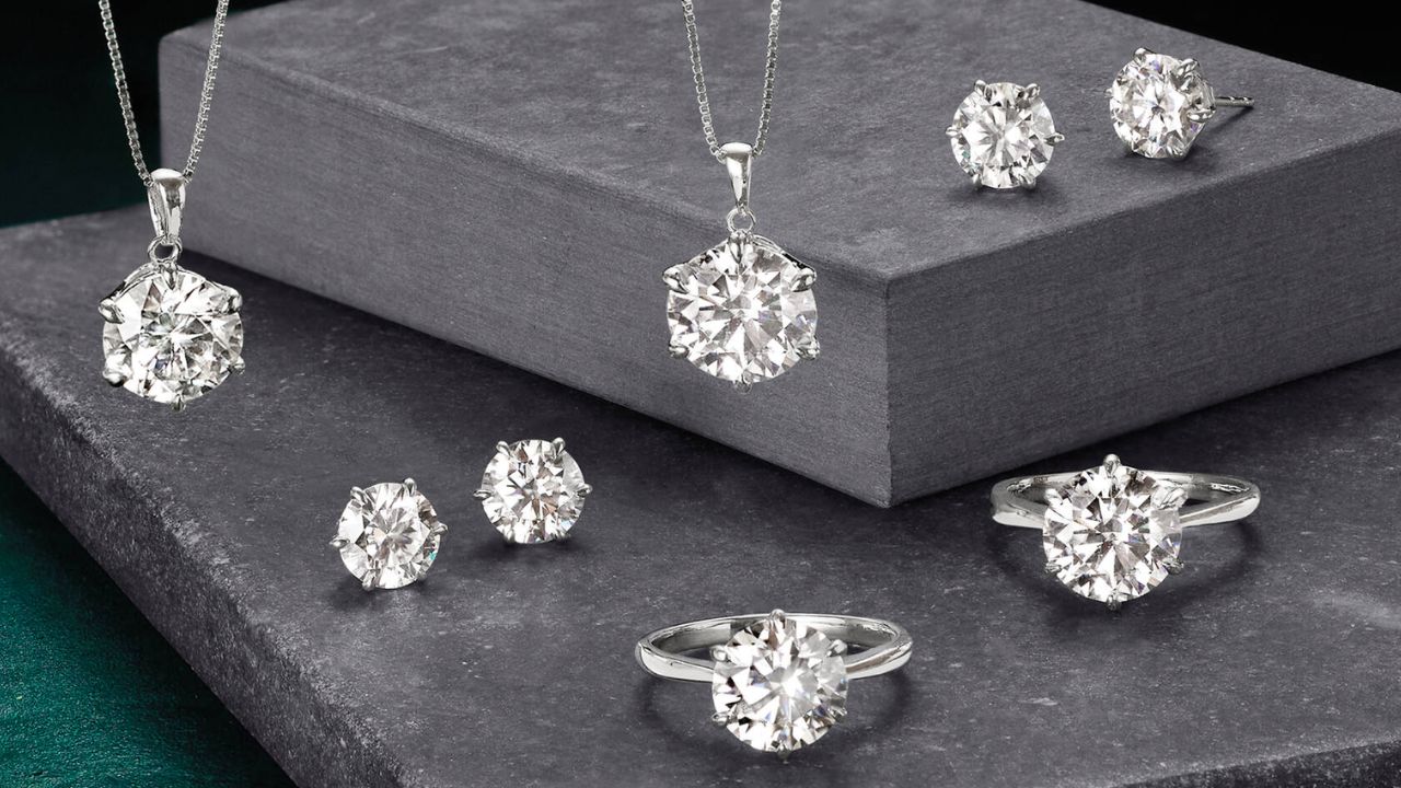 Various moissanite rings, including solitaire and halo settings, displayed on a jewelry stand.