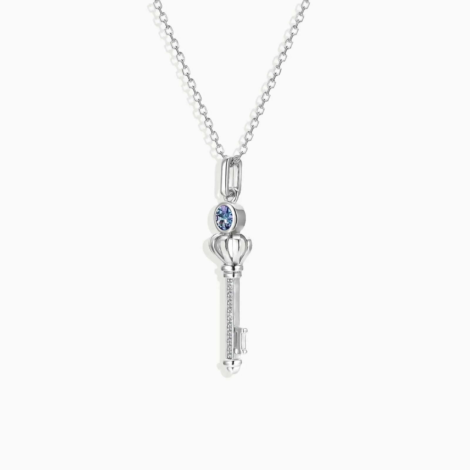 Key-shaped pendant with Alexandrite centre on rhodium-plated trace chain – meaningful jewellery design