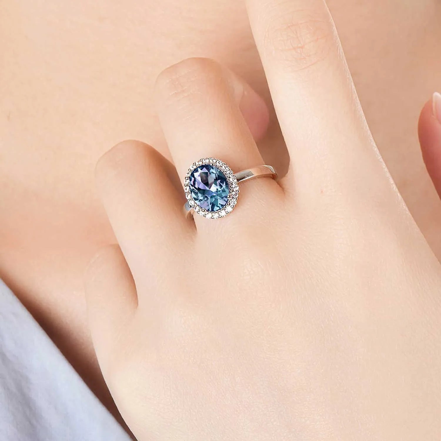 Alexandrite halo ring worn on finger – blue to purple gemstone jewellery for June birthdays