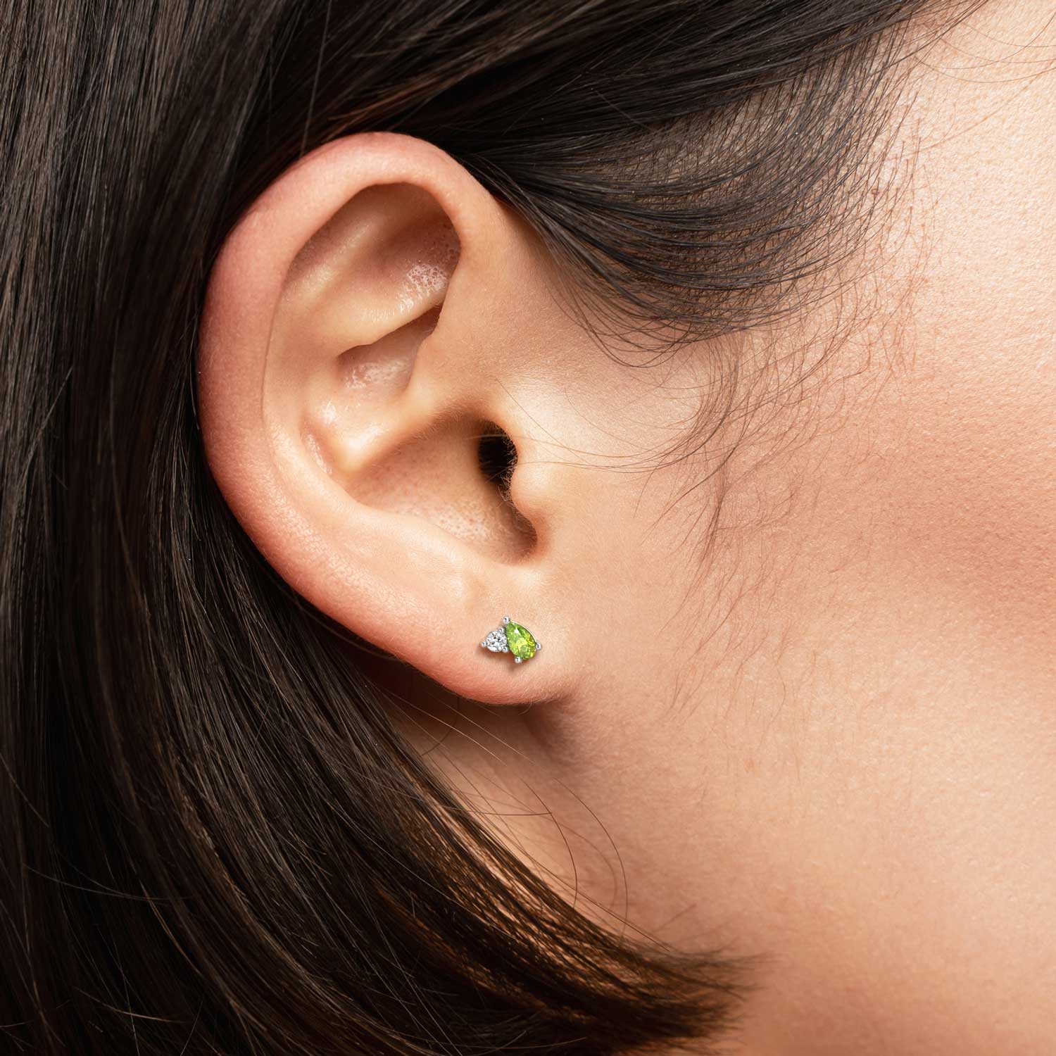 Model wearing peridot and diamond simulant silver stud earrings – elegant and lightweight design