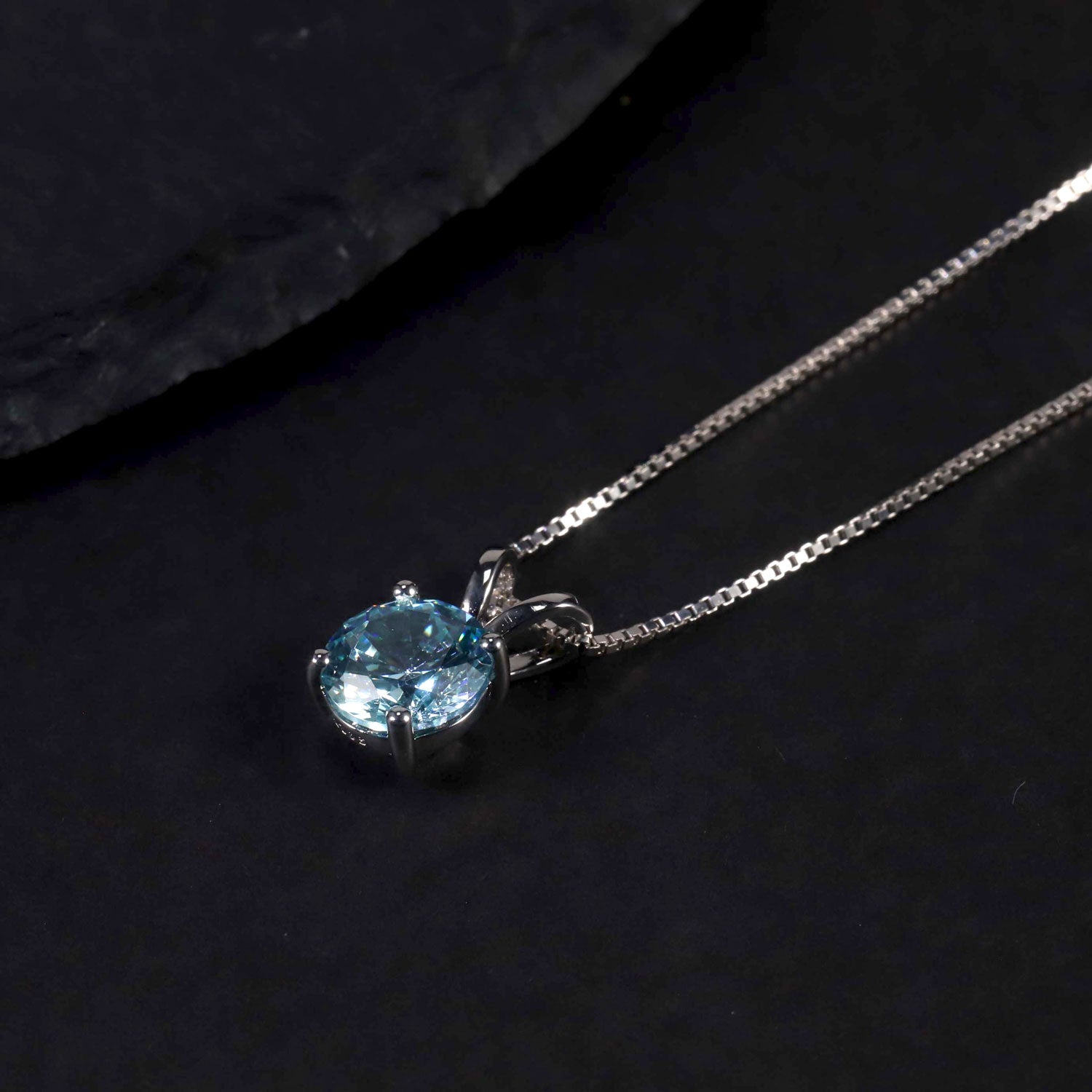 aquamarine round shape pendant necklace on dark background