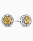 Pair of yellow citrine gemstone earrings with silver halos on a white background