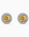 Pair of yellow citrine gemstone earrings with diamond halo on a white background