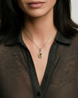 Woman wearing a citrine halo necklace with a teardrop-shaped pendant against a neutral background