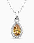 Teardrop-shaped pendant with a yellow citrine gemstone and diamond accents on a white background