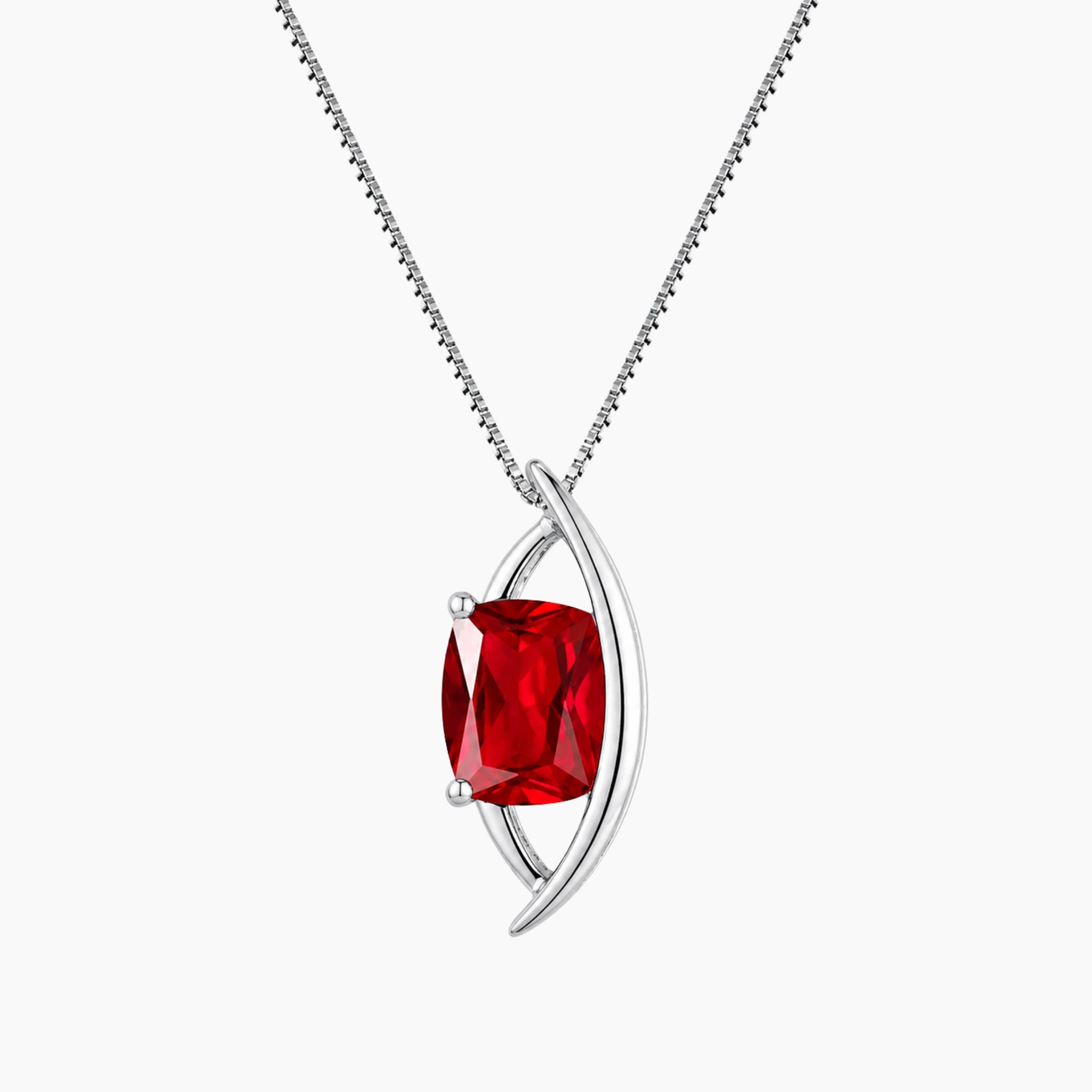 Silver necklace with a red cushion cut ruby gemstone on a white background