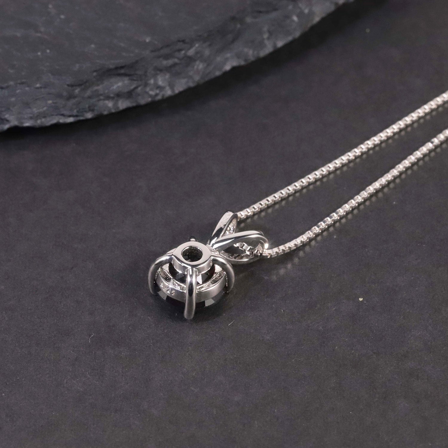 backside of garnet round pendant on black background