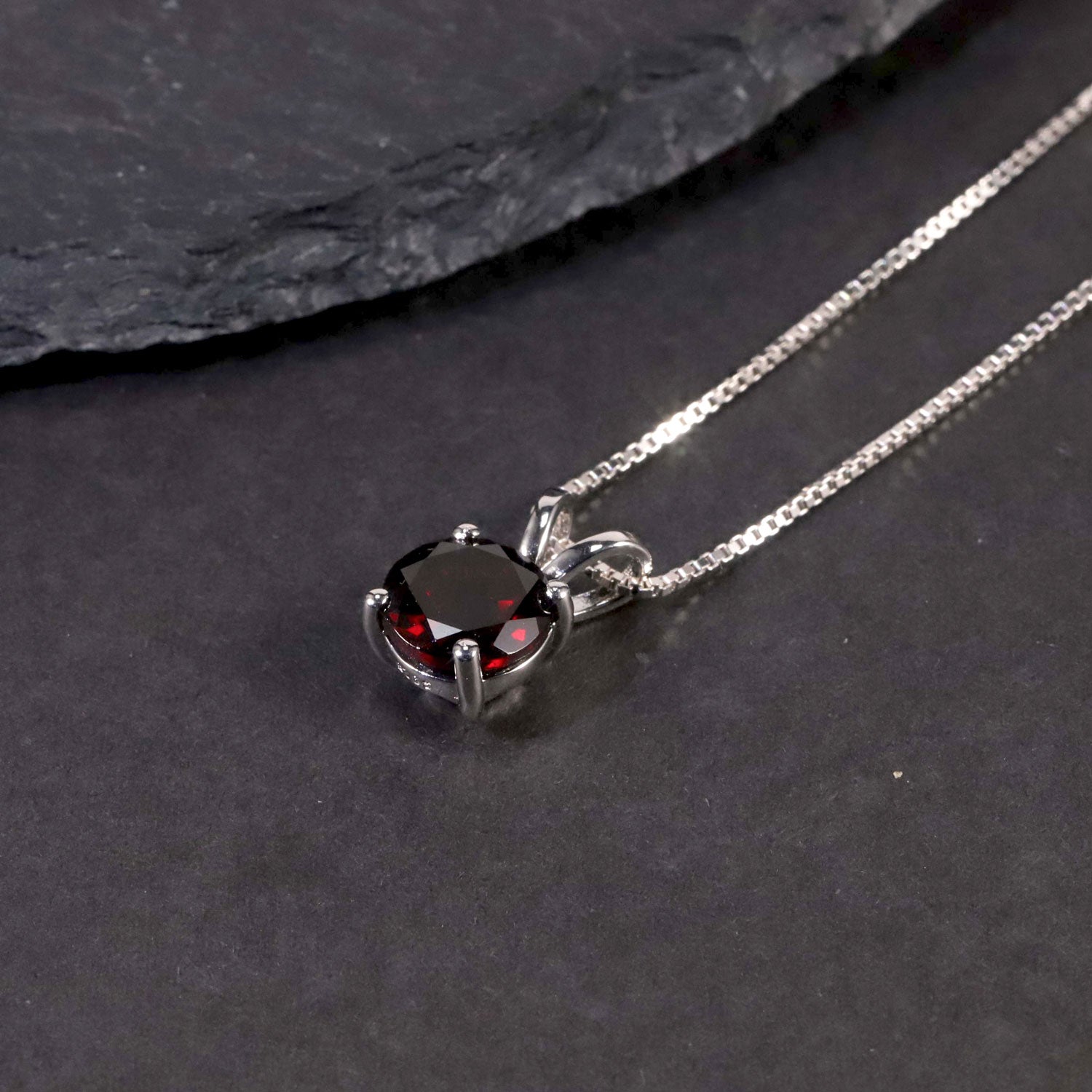 garnet round shape necklace on black background