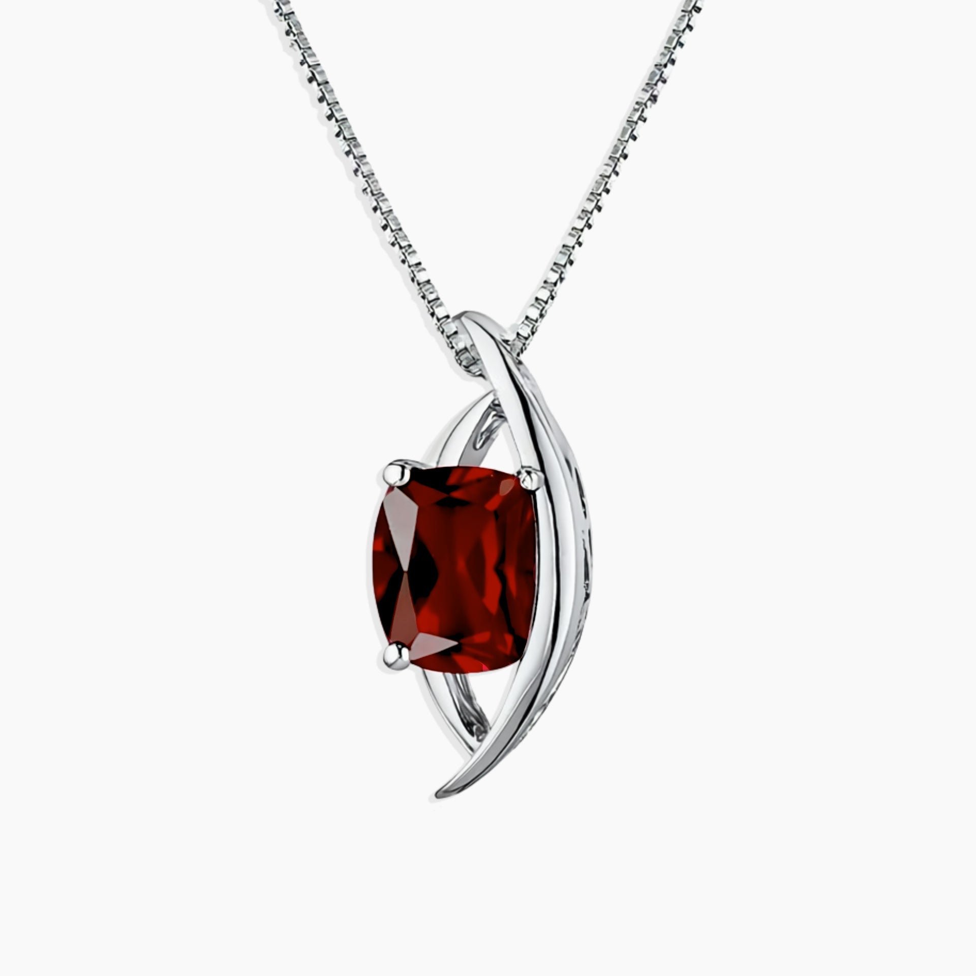 Silver pendant with a red gemstone on a white background