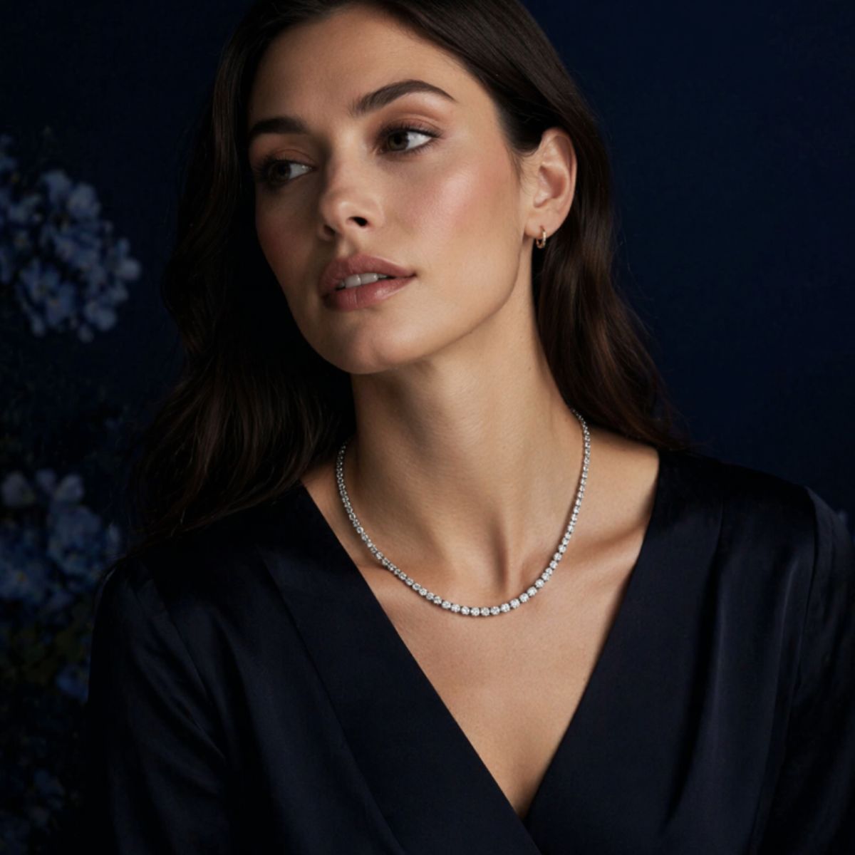 Woman wearing a irosk tennis necklace against a dark background