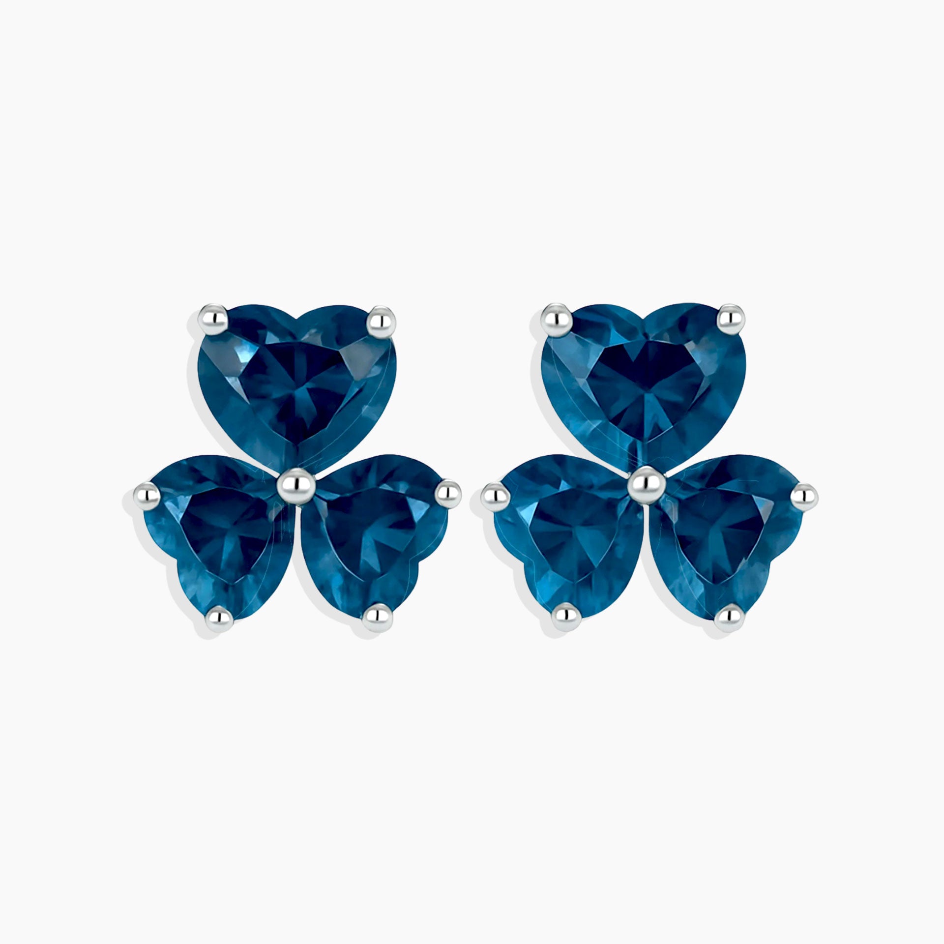 Pair of blue heart-shaped stud earrings on a white background