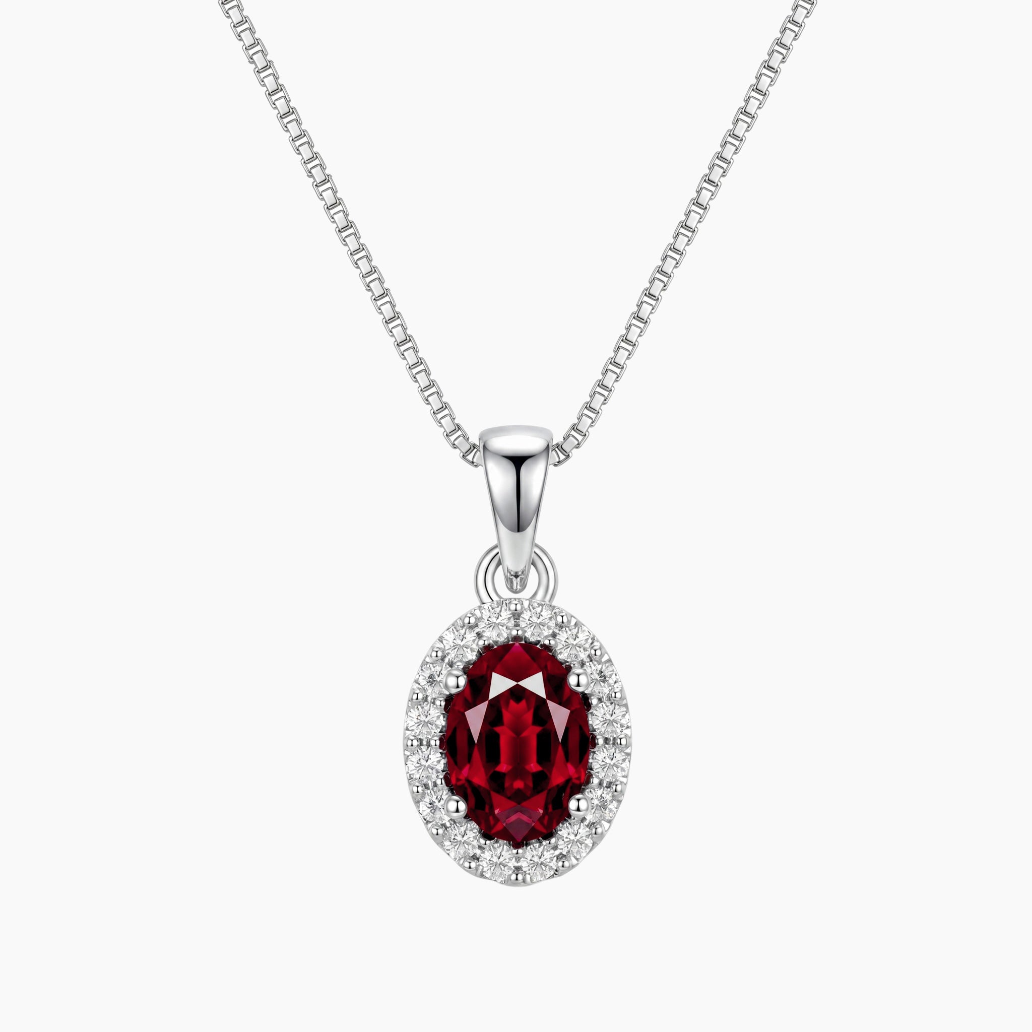 Silver necklace with a red ruby oval gemstone halo pendant on a white background