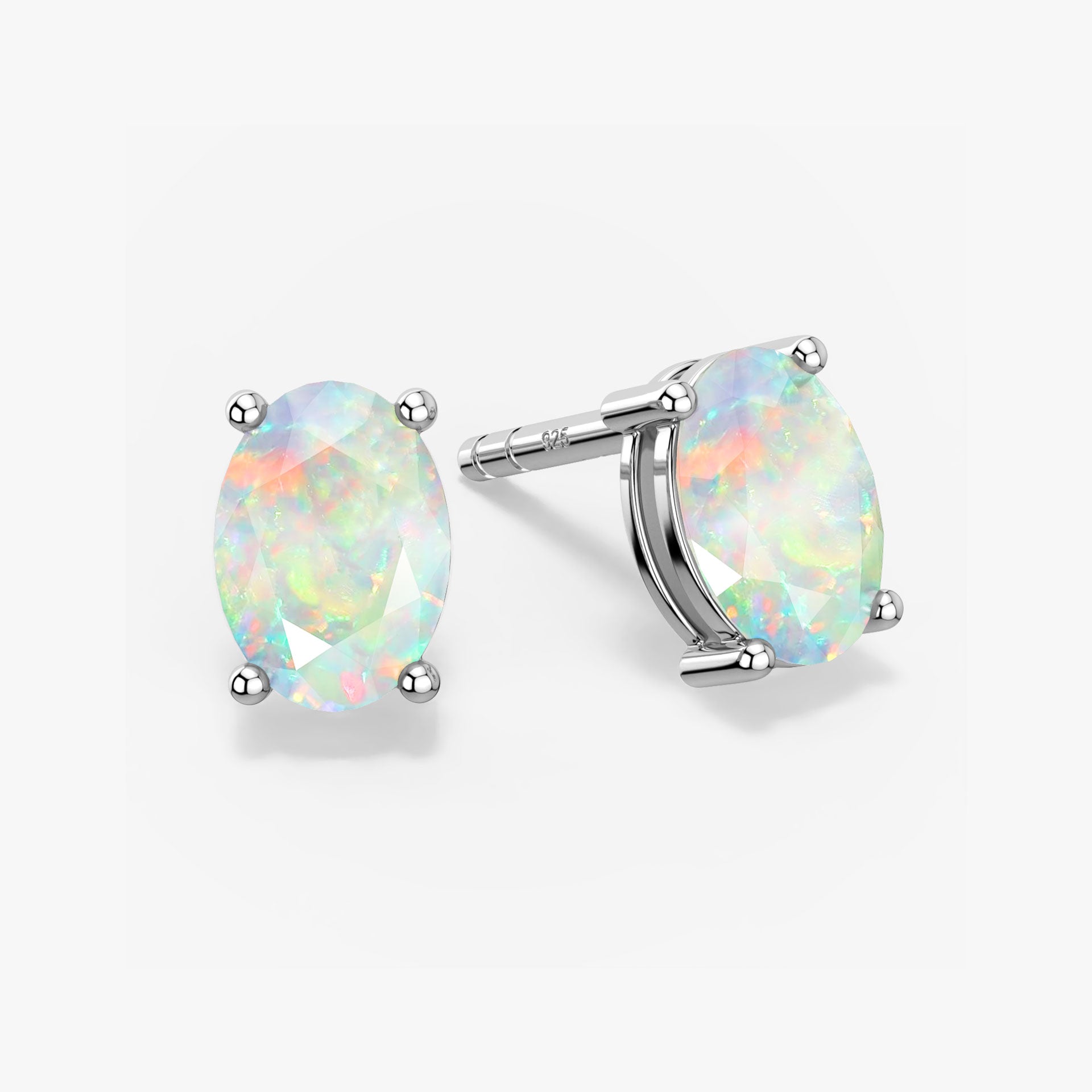 Pair of oval-cut white opal stud earrings with iridescent rainbow flashes, set in four-prong silver settings with push-back closures, displayed on a white background
