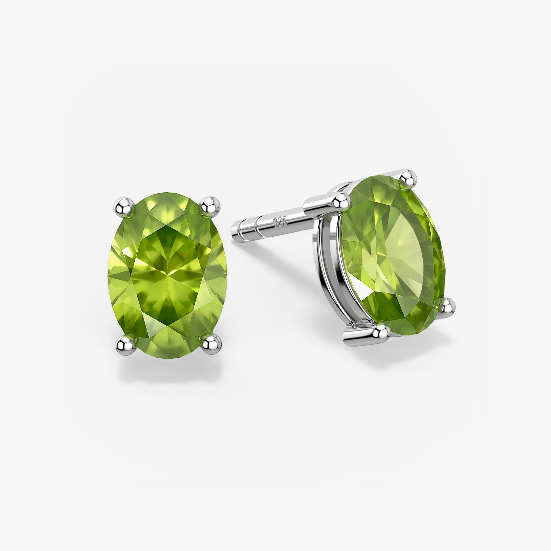 Pair of oval-cut green peridot stud earrings in a four-prong silver setting with push-back closures, displayed on a white background.