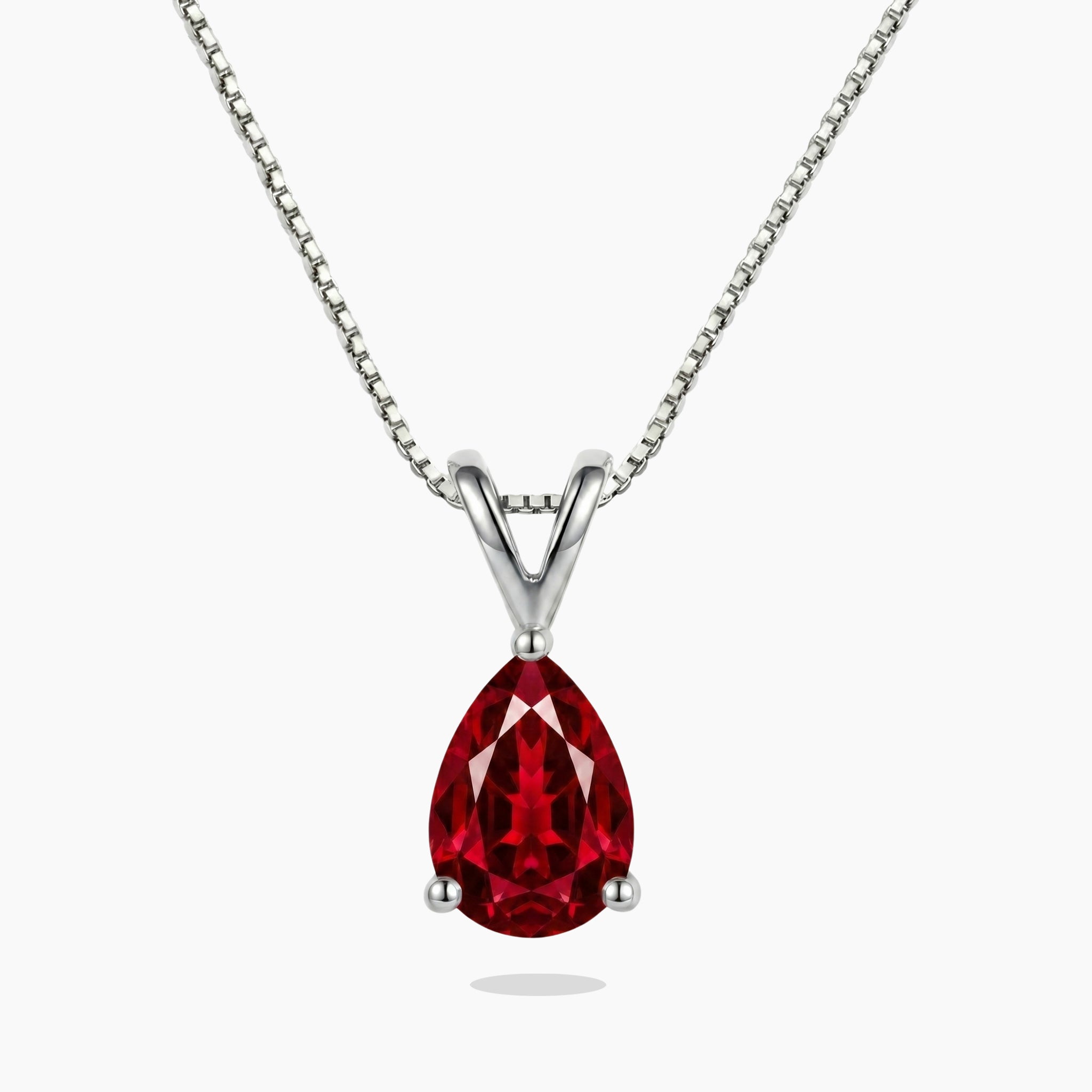 Red ruby teardrop-shaped gemstone necklace on a white background