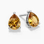 Two pear-shaped citrine stud earrings in sterling silver three-prong settings—one facing forward and the other angled slightly—featuring vibrant golden-yellow gemstones with brilliant facets, displayed on a clean white background.