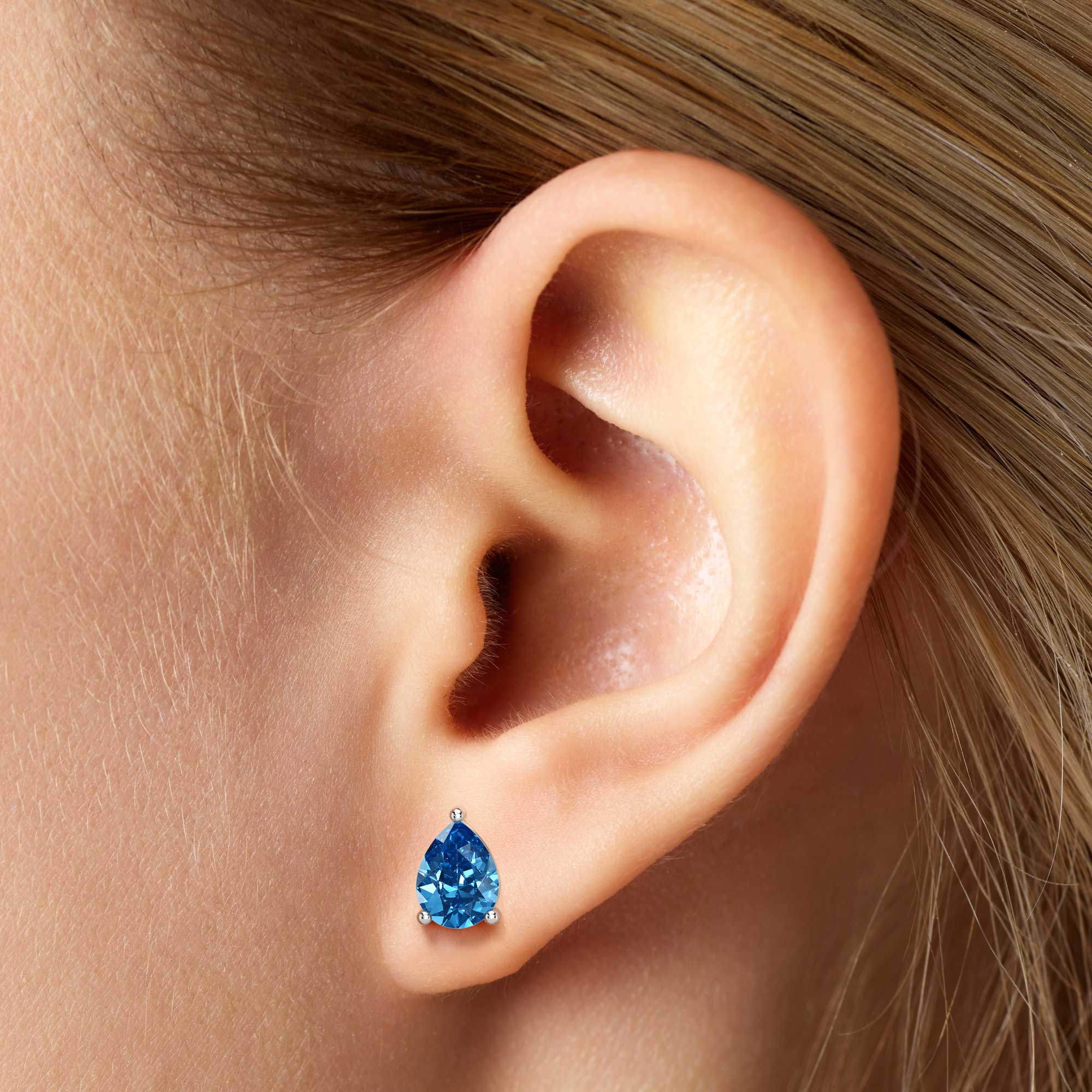 pear shape london blue topaz earrings on model ear