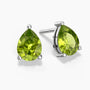Two pear-shaped bright green peridot gemstones set as sterling silver stud earrings, one shown head-on and the other at a slight angle, each secured by three polished prongs on a white background.