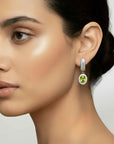 Close-up of a woman wearing a green  peridot gemstone earring with a neutral background