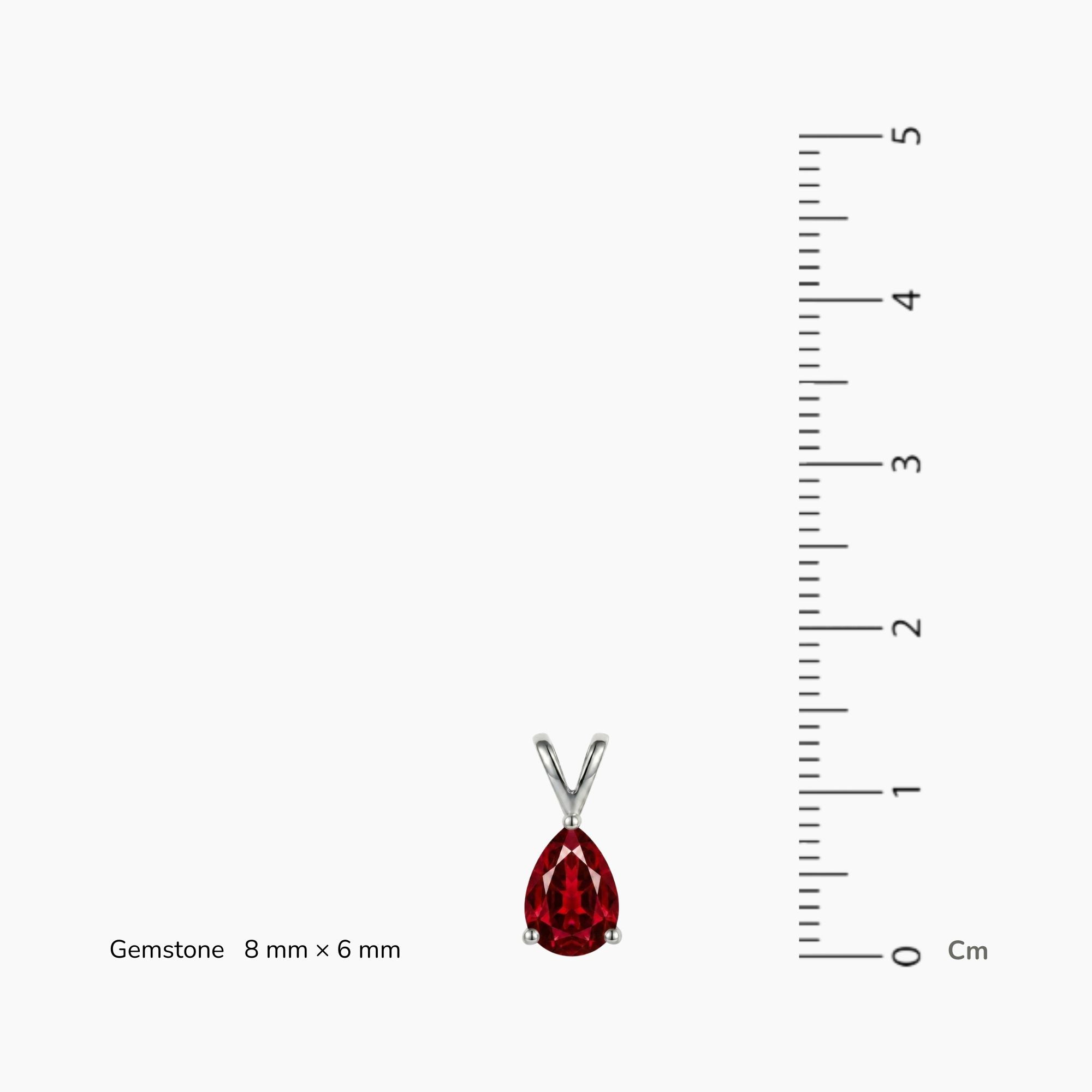 Red ruby gemstone pendant with silver chain next to a ruler on a white background