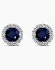 Pair of sapphire earrings with diamond halo on a white background
