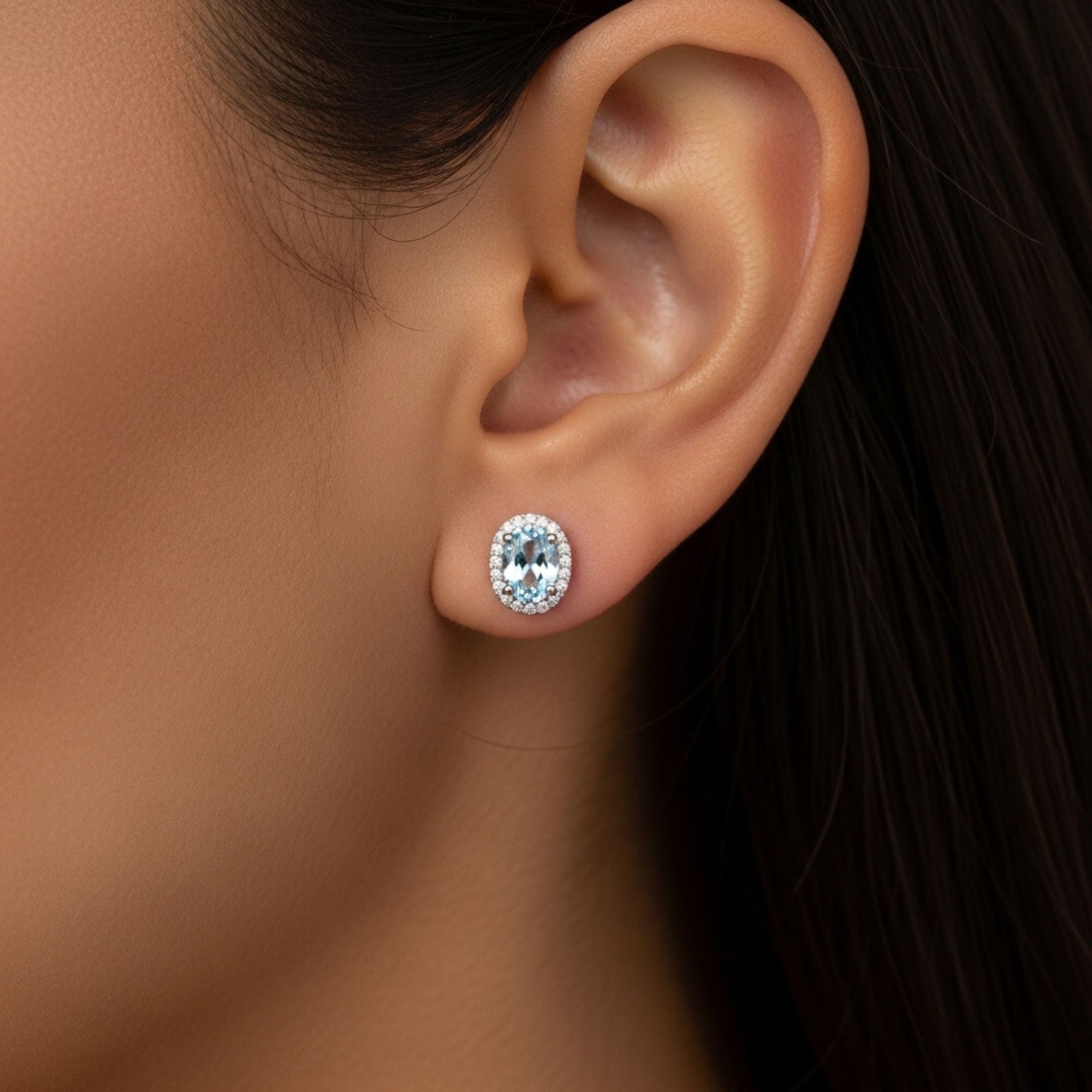 oval aquamarine halo studs on model ear