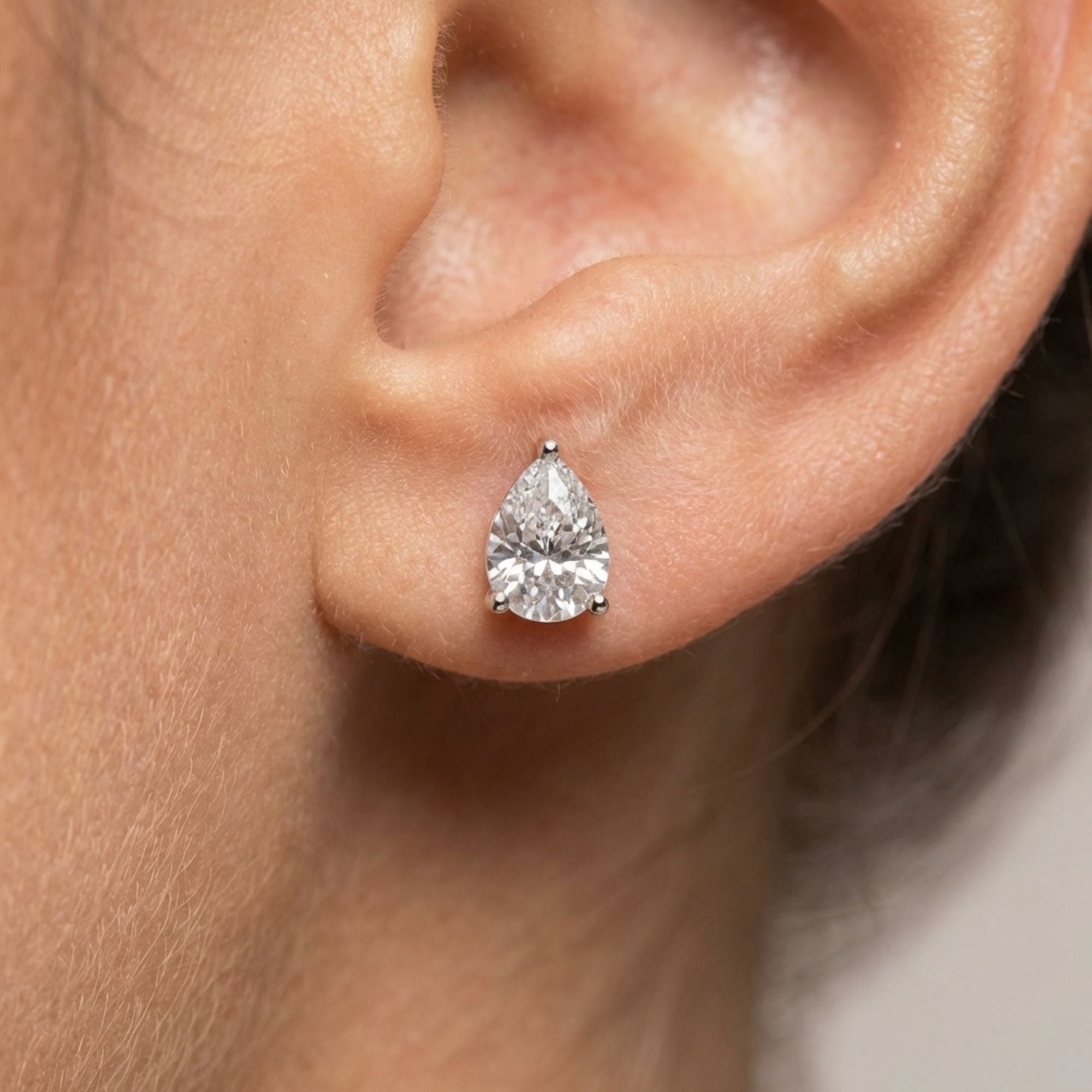 pear shape moissanite earring on a person's ear