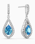 Teardrop-shaped earrings with swiss blue topaz gemstones and clear stones on a white background