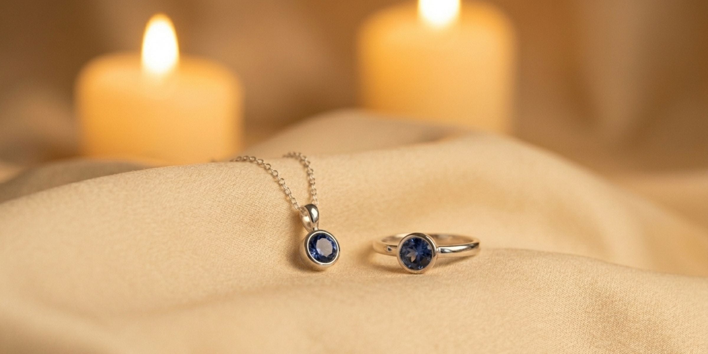 Sterling silver blue sapphire ring and pendant on ivory silk with soft candlelight