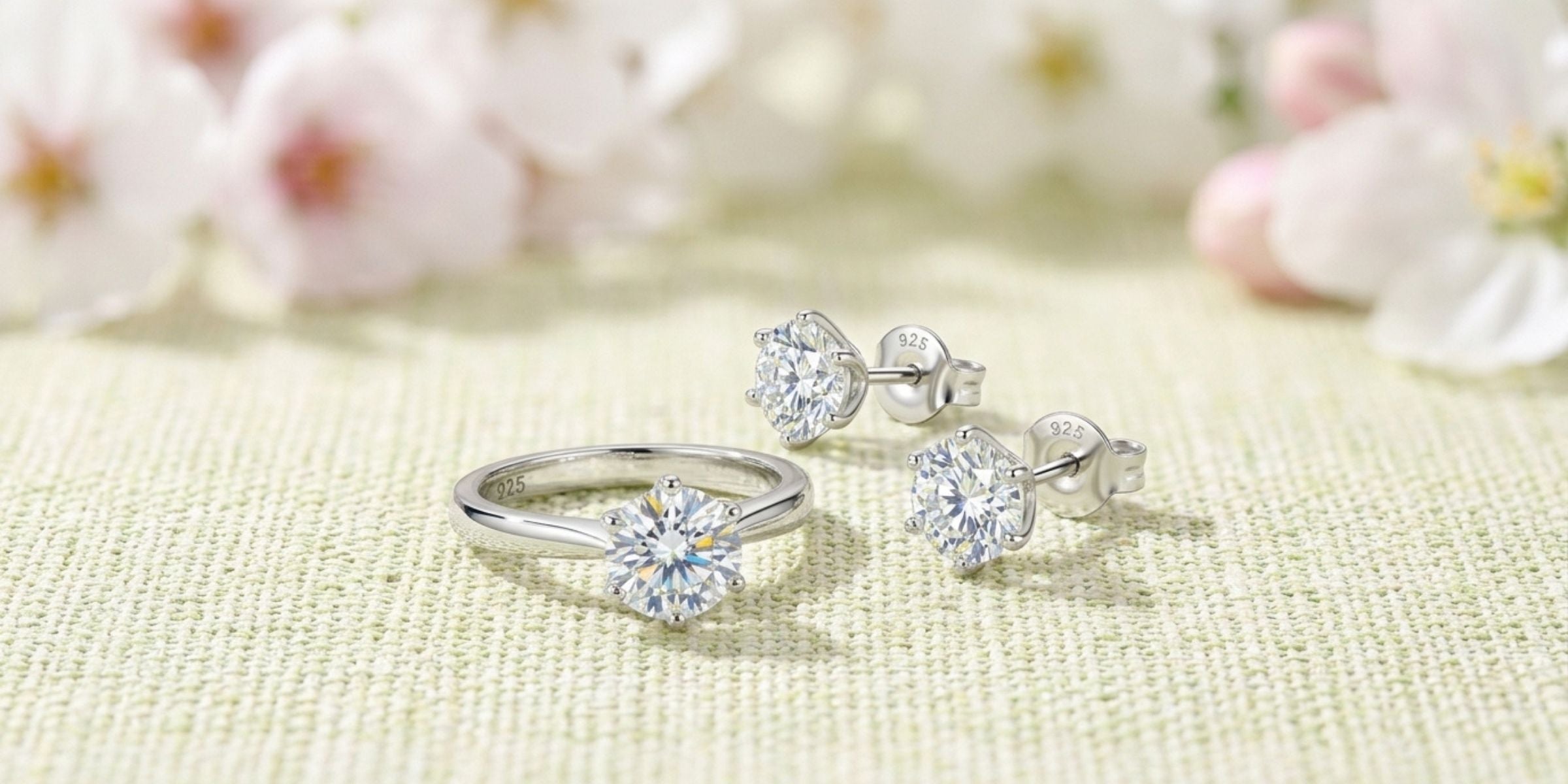 Sterling silver moissanite ring and stud earrings with soft spring blossom background