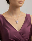 Woman wearing a purple dress with a necklace featuring a amethyst angel pendant