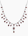 Necklace with red garnet gemstones and silver chain on a white background