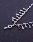 Silver necklace with decorative elements on a dark background