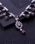 Delicate necklace with red gemstones and silver accents on a dark background