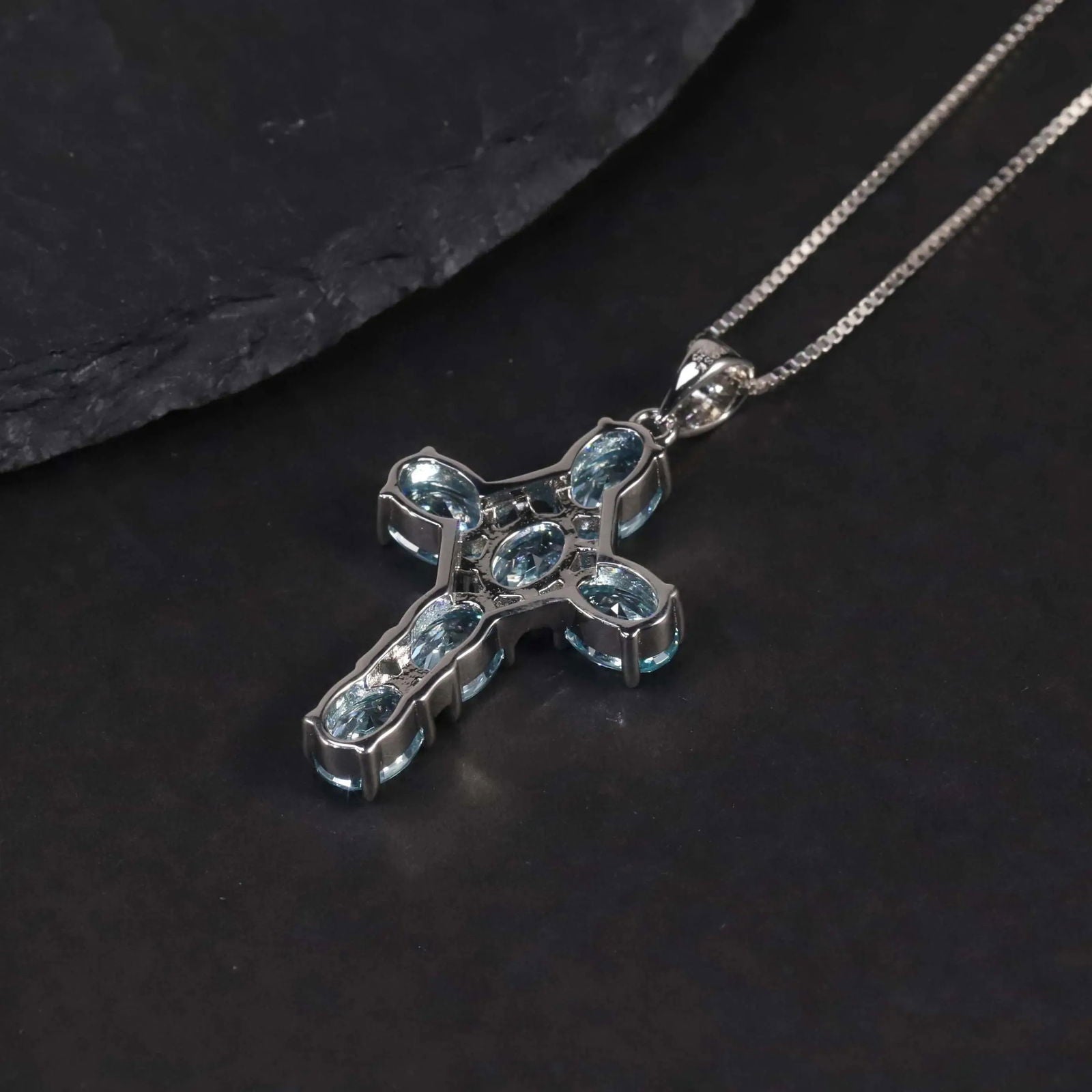 Side view of the aquamarine cross pendant, emphasizing the shine and clarity of the aquamarine gemstones.