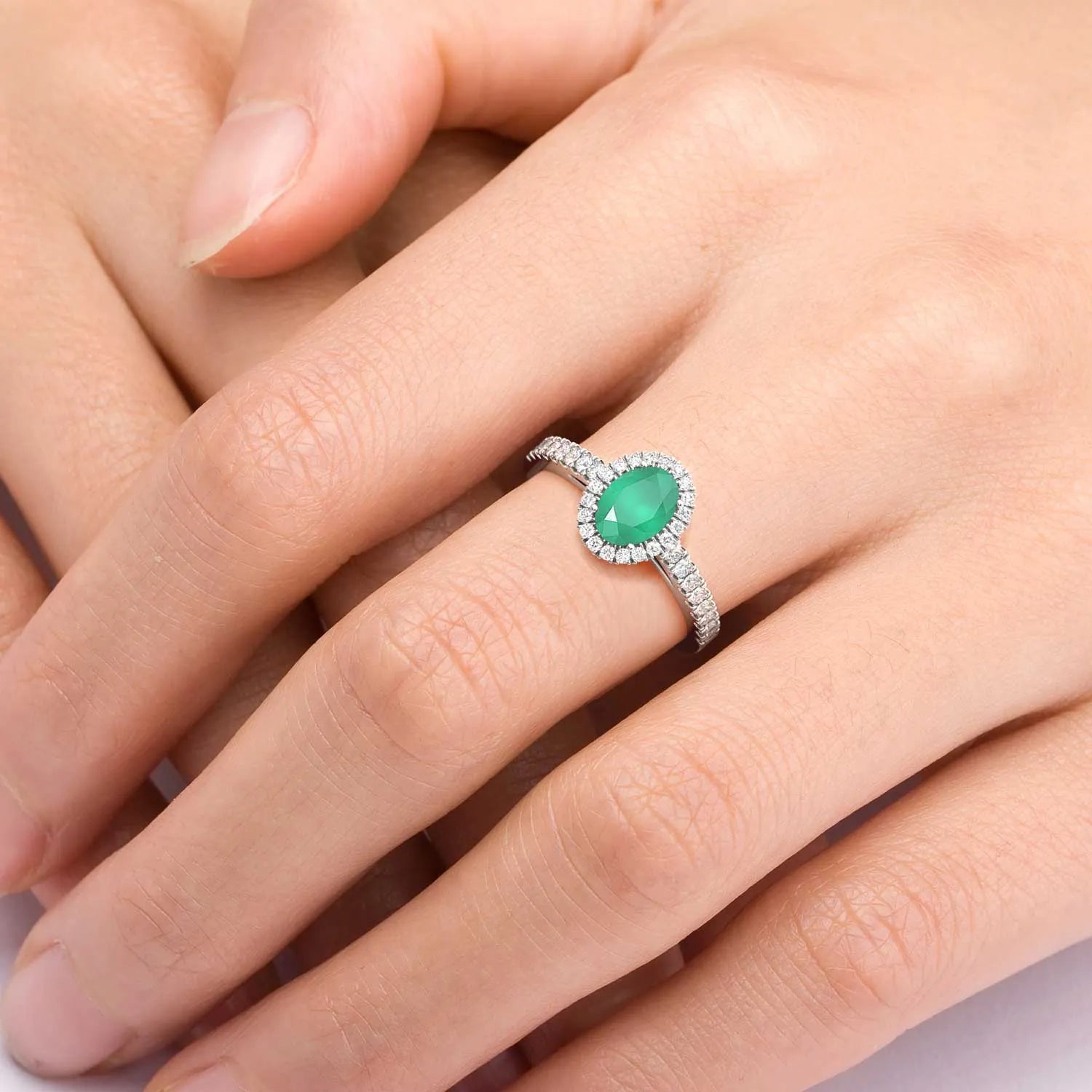 Sterling silver oval-cut emerald halo ring with a 5 × 7 mm natural Sakota emerald surrounded by sparkling CZ.