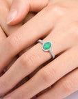 Sterling silver oval-cut emerald halo ring with a 5 × 7 mm natural Sakota emerald surrounded by sparkling CZ.