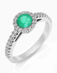 Angled view of the round-cut emerald halo ring in rhodium-plated sterling silver, highlighting the 5 mm gemstone.