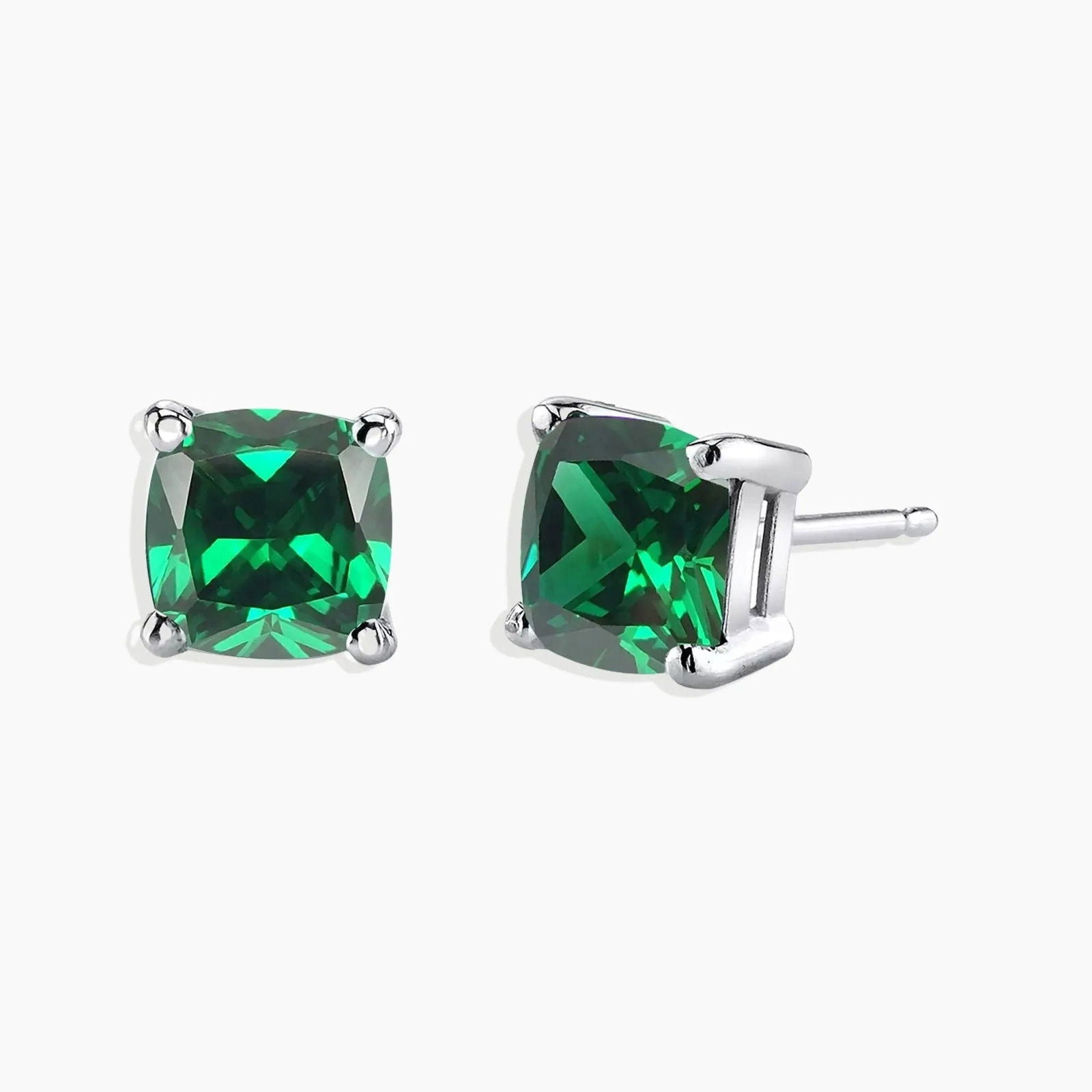 Sterling silver stud earrings featuring cushion-cut emeralds on a white background.