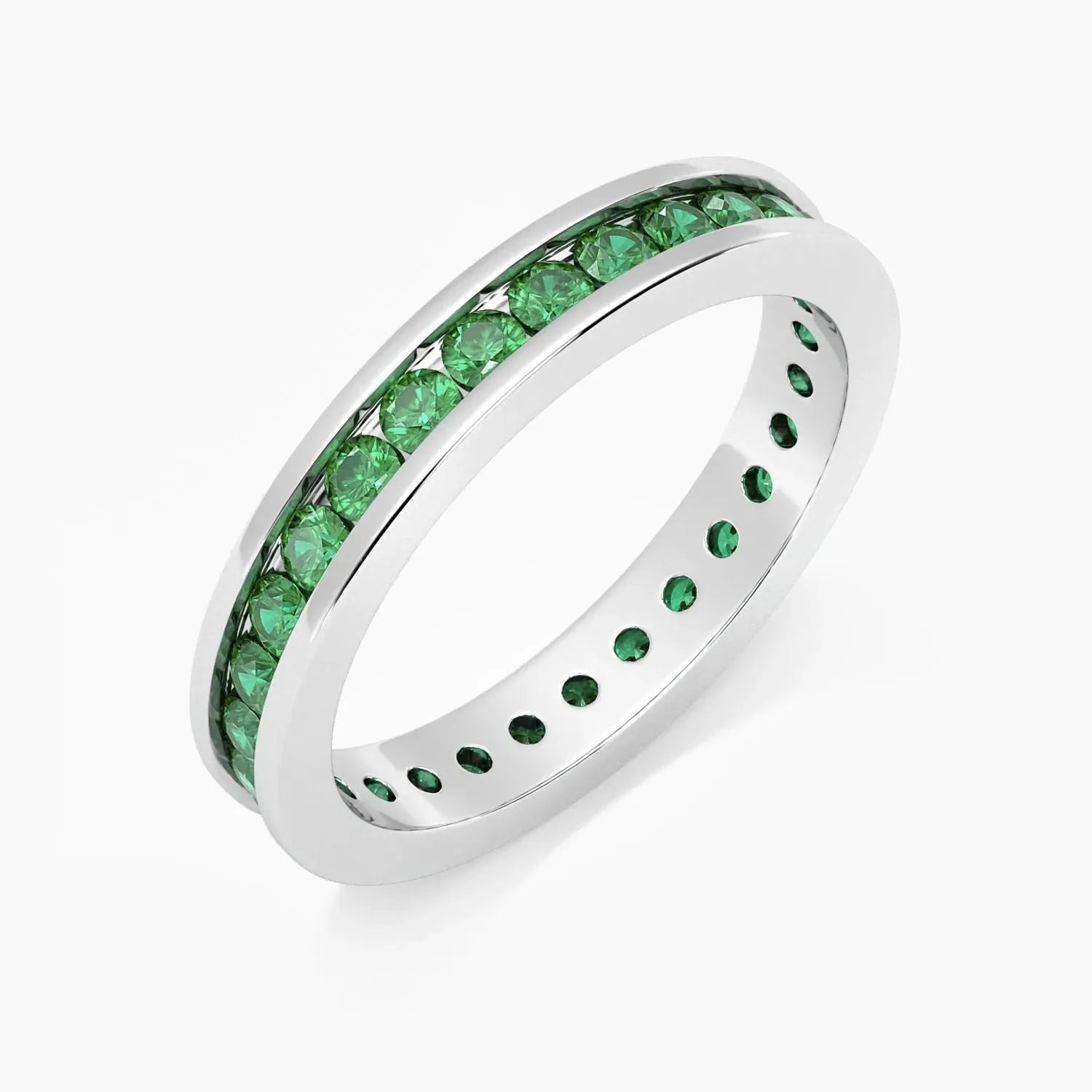 Angled view of the emerald channel-set ring in rhodium-plated sterling silver, highlighting the row of green stones.