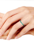 Woman wearing the sterling silver emerald channel-set ring on her hand, showing its elegant fit and sparkle.