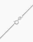 Close-up showing the sterling silver box chain and spring ring clasp for the pear emerald necklace.