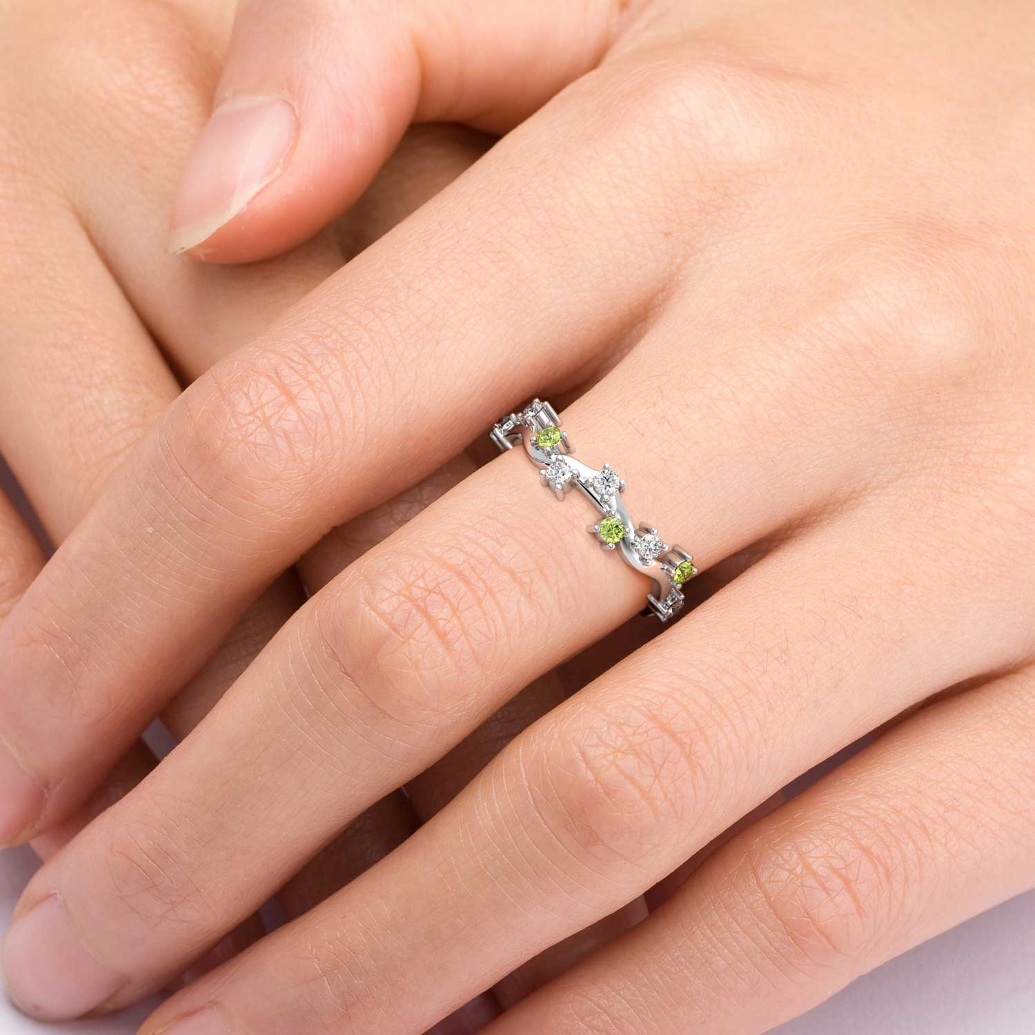 Hand wearing a Peridot Galaxy ring, showcasing a vibrant peridot gemstone set in a galaxy-inspired silver band.