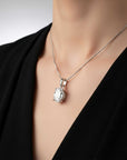 Silver necklace with a pendant on a mannequin wearing a black top.