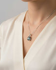 Necklace with a london blue topaz pendant worn by a person in a beige outfit against a neutral background