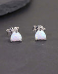 heart opal earrings on black background