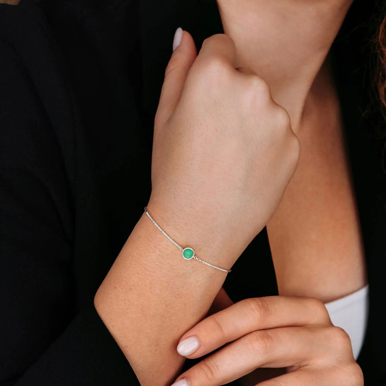 Woman wearing the sterling silver emerald bracelet on her wrist, highlighting the vibrant green gemstone