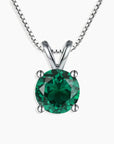 Sterling silver necklace featuring a round-cut emerald pendant on a white background.