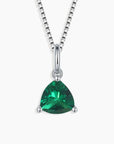 Sterling silver necklace featuring a trillion-cut emerald pendant on a white background.