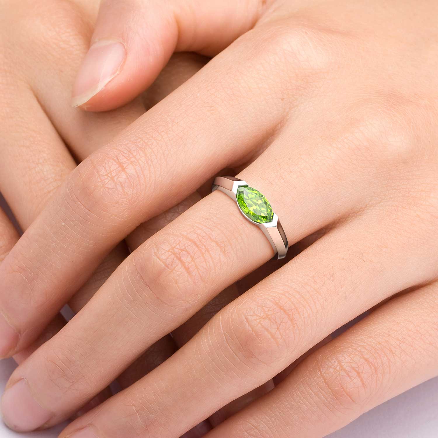 close up of peridot marquise cut ring worn on hand 
